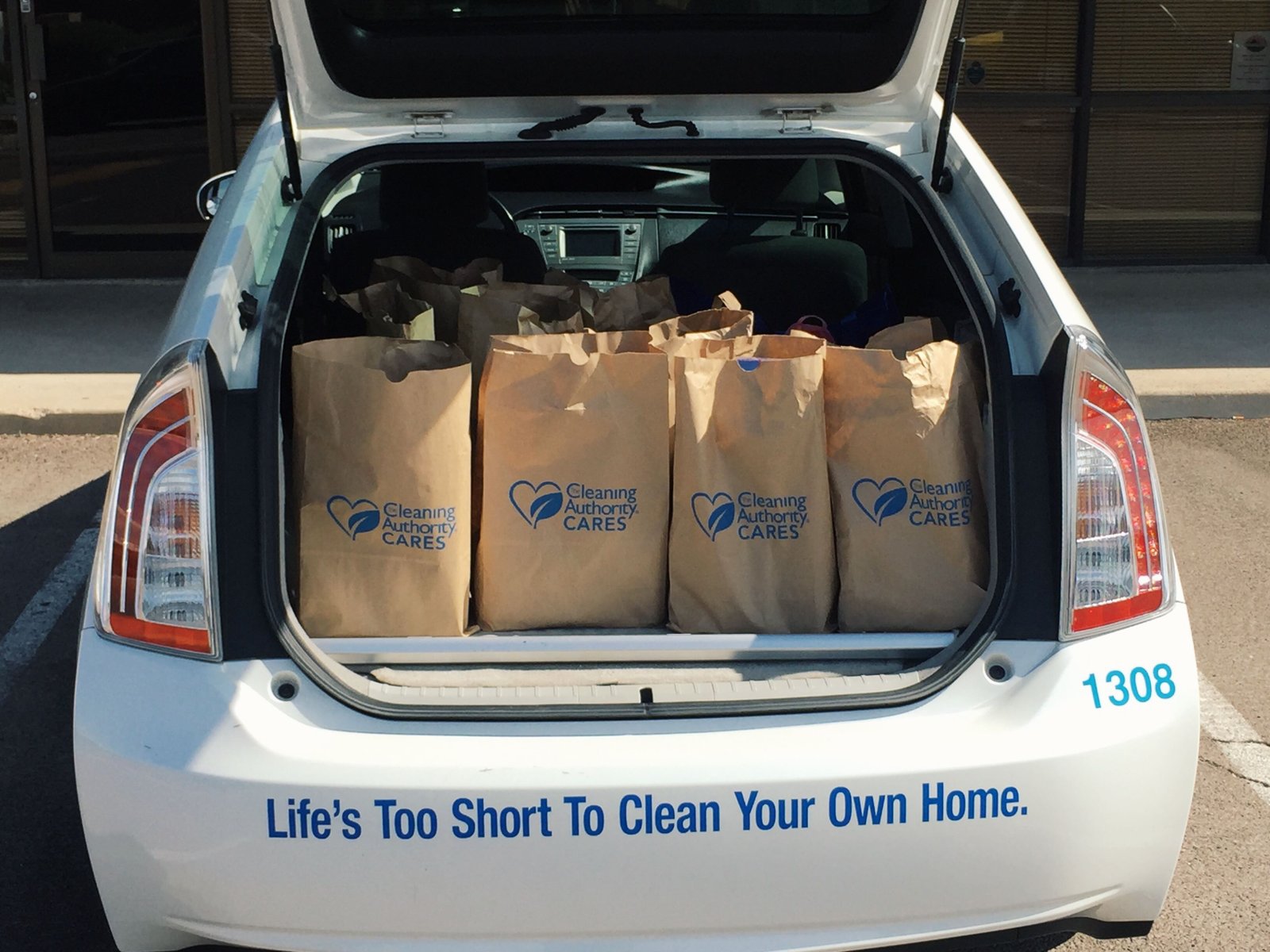 Multiple bags of food donations collected by TCA East Valley sit in the back of a white vehicle.