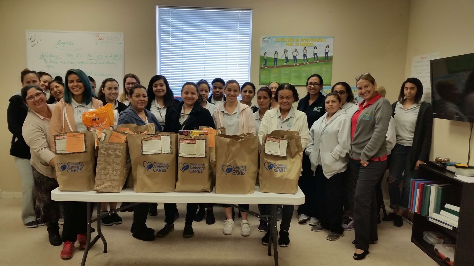 The TCA San Antonio team stands in their office with donations collected for a local charity.